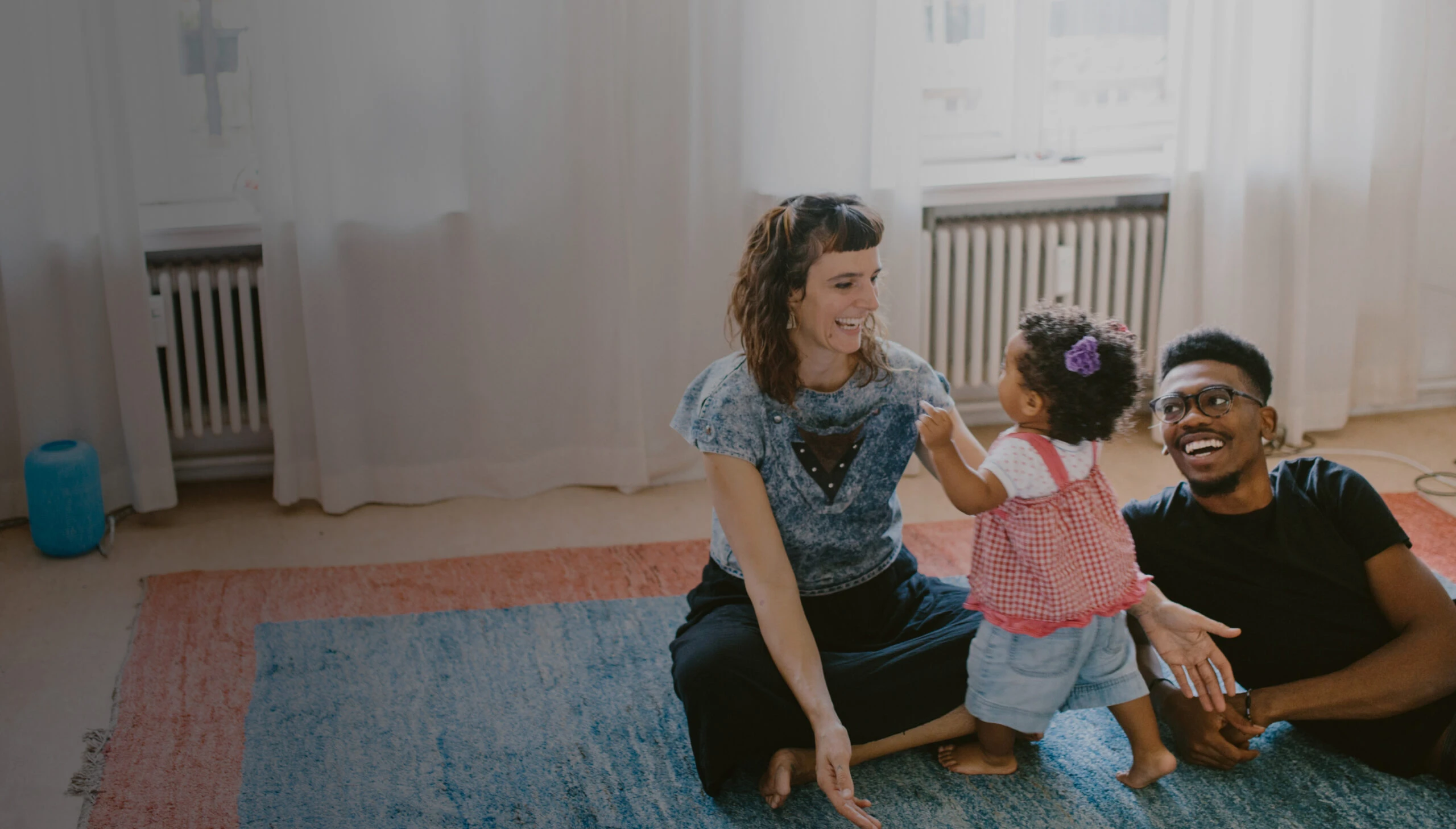 Parents sitting on the floor playing with their child