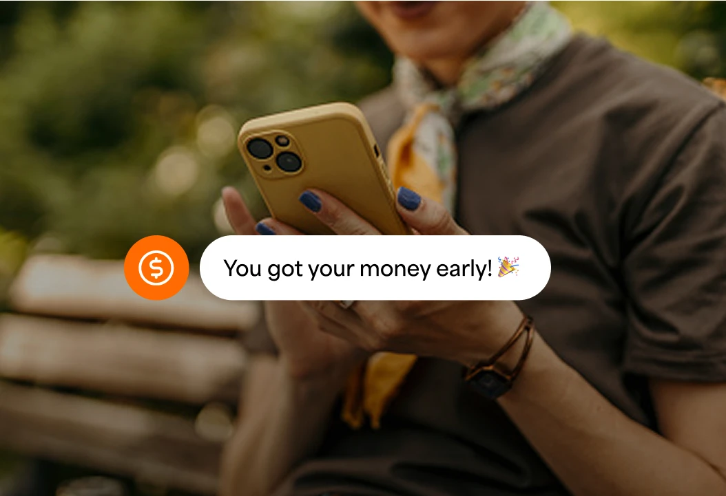 Person on a phone with a notification of getting their money early