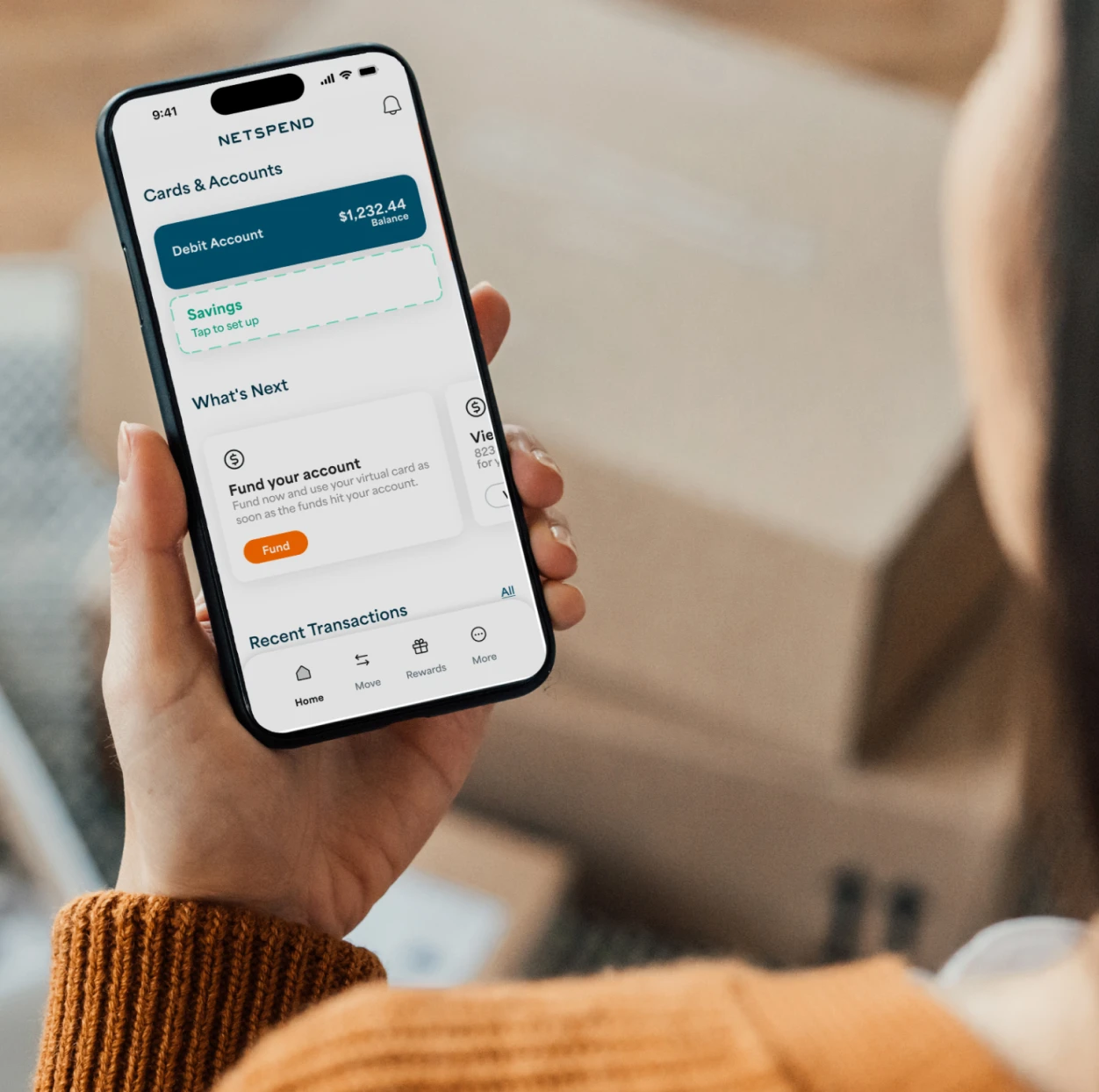 Woman holding an iPhone showing her account balance in the Netspend appt