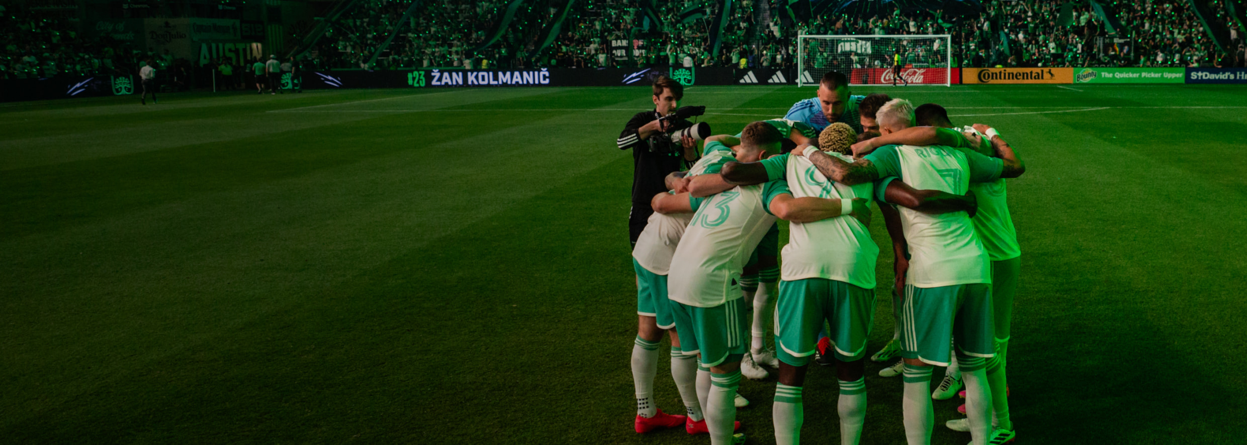 Austin FC players in a huddle on field