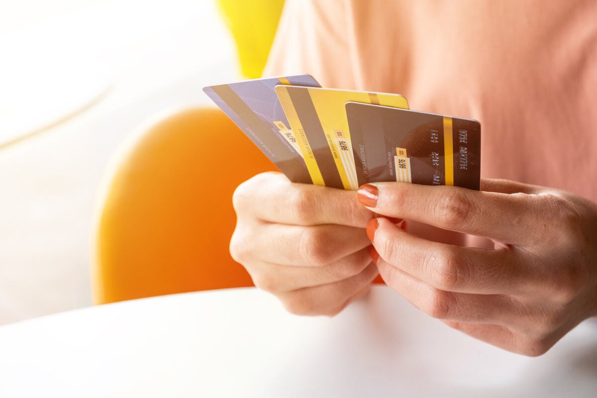 Woman looking at a prepaid, credit and debit card.